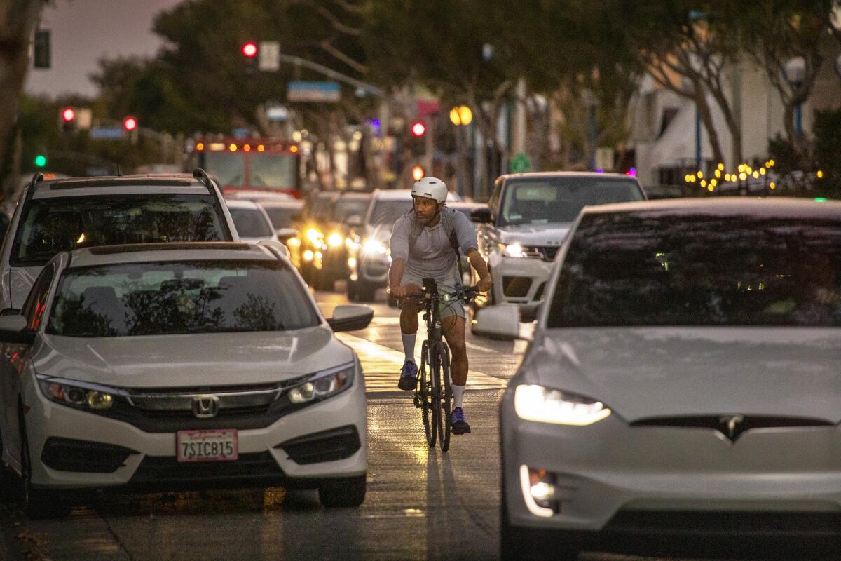A cyclist rides amid heavy traffic on Santa Monica Boulevard in West Hollywood on Oct. 28, 2021. 