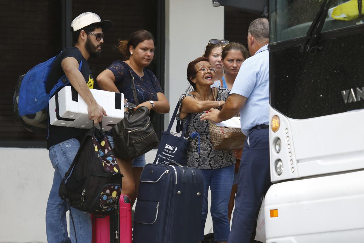 In downtown Miami, people wait to get on a bus headed to Orlando under a mandatory evacuation plan.