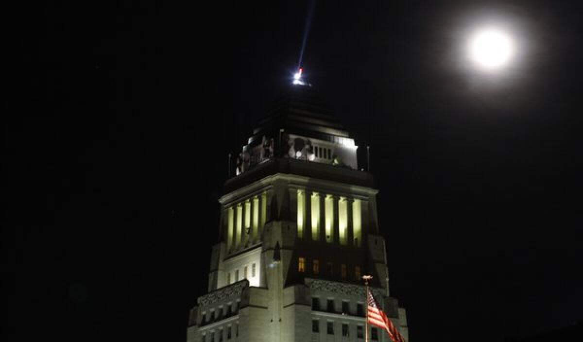 One kind of blue moon, the second in one calendar month, rises over Los Angeles City Hall on Dec. 31, 2009. A different kind of blue moon will shine above the Southland tonight.