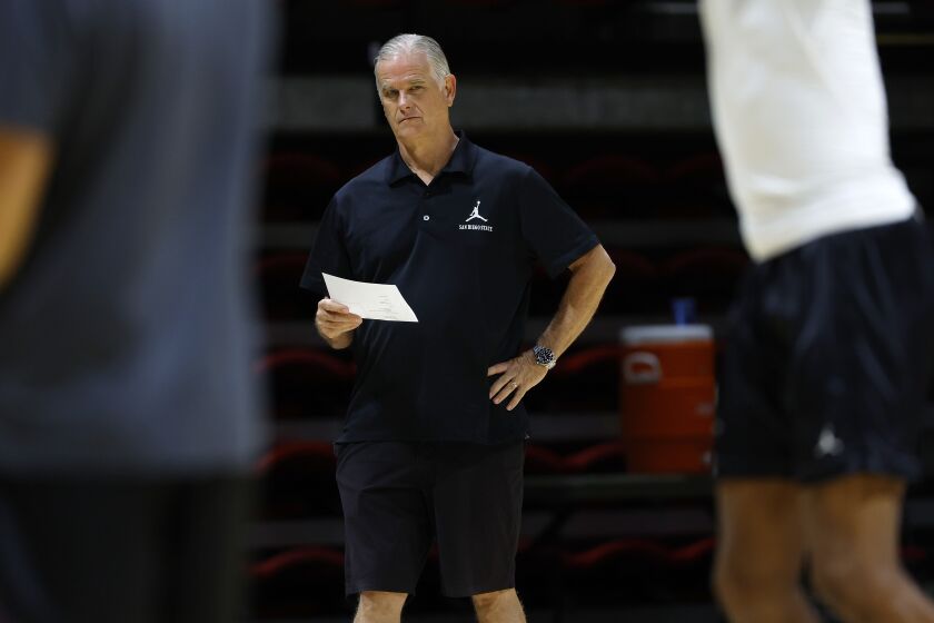 San Diego State basketball coach Brian Dutcher talks with his team during a practice at Viejas Arena.