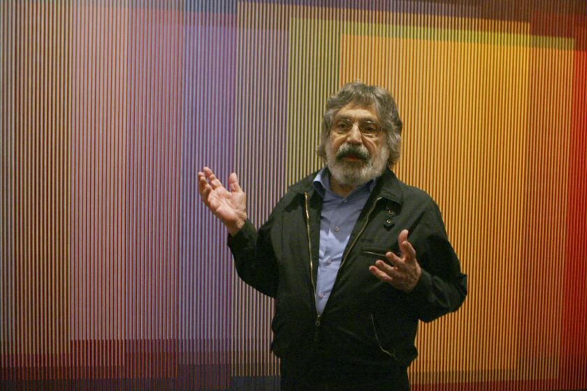 FILE - In this Sept. 10, 2008, file photo, Venezuelan artist Carlos Cruz-Diez talks about his Physichromie no. 500 in New York. Cruz-Diez, a leading Latin American avant-garde artist praised for his work with color, died Saturday, July 27, 2019, in Paris surrounded by his family, according to his official website. He was 95. (AP Photo/Mary Altaffer, file)