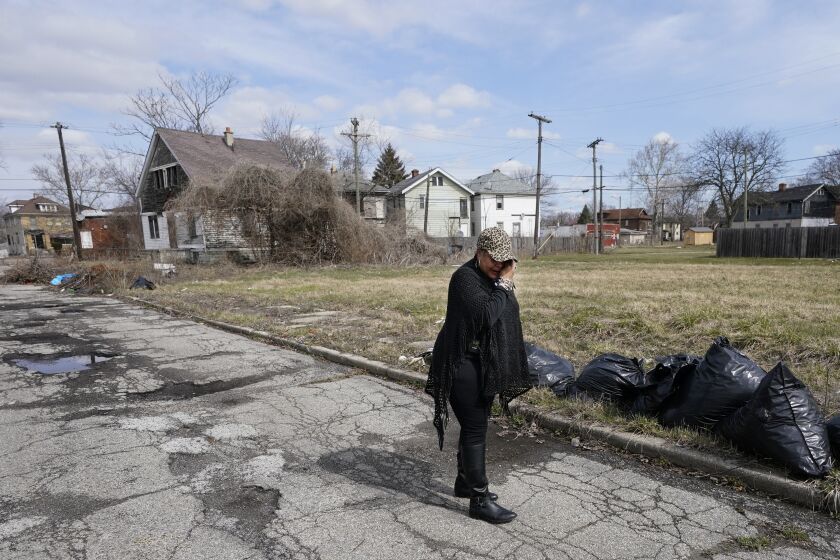 Bernice Ringo wipes her eyes, Tuesday, March 28, 2023 in Detroit, as she looks at the site where her son was fatally shot while sitting in his car in 2019. Natalian was fatally shot while sitting in his car in 2019. After being denied victim compensation and overwhelmed with grief, Ringo spoke to the Michigan Legislature about the trauma of being told her son had caused his murder. (AP Photo/Carlos Osorio)