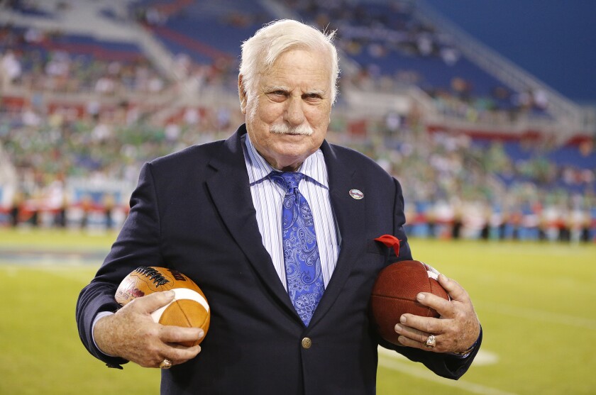 Howard Schnellenberger holds two footballs while near the field of the Boca Raton Bowl.