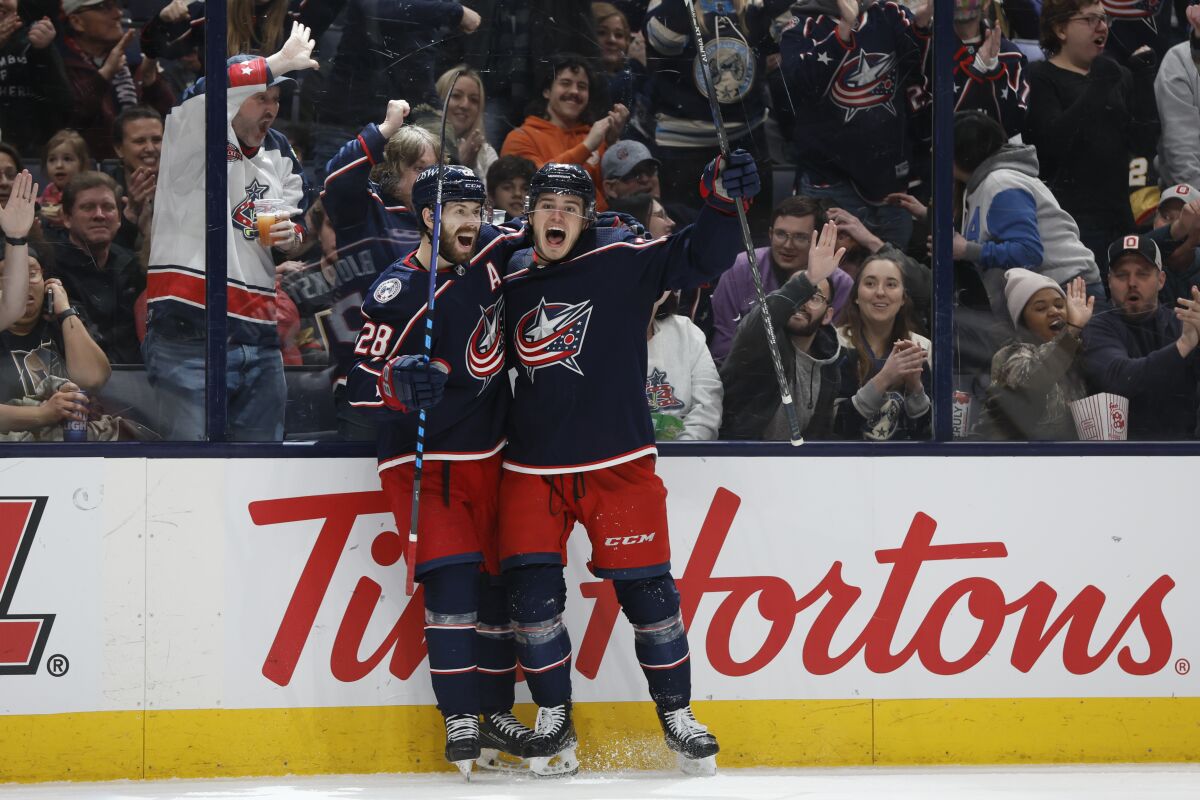 Columbus Blue Jackets' Cole Sillinger, right, celebrates his hat trick against the Vegas Golden Knights with teammate Oliver Bjorkstrand during the second period of an NHL hockey game Sunday, March 13, 2022, in Columbus, Ohio. (AP Photo/Jay LaPrete)