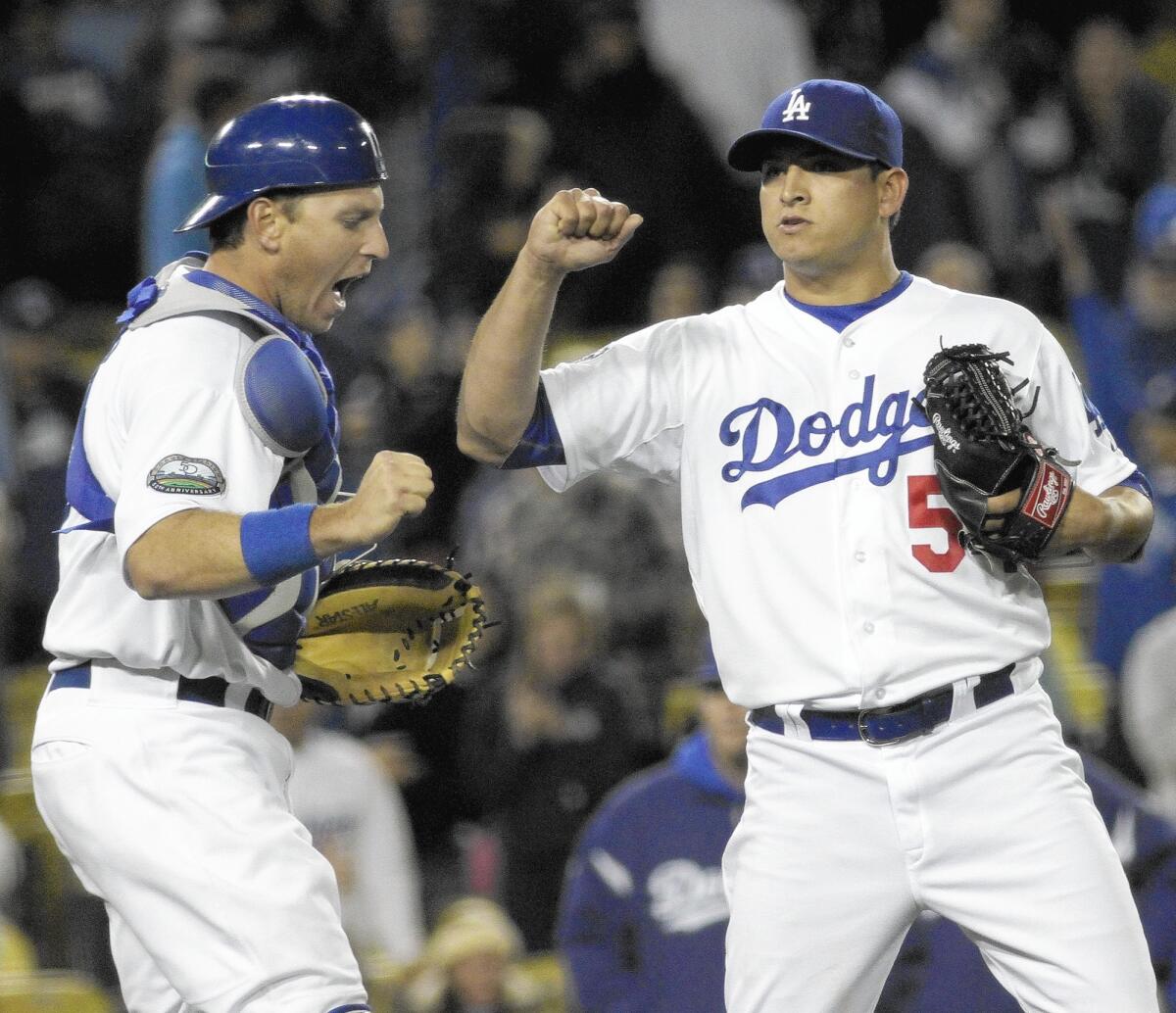 Dodgers catcher A.J. Ellis celebrates a victory with reliever Javy Guerra on April 11, 2012.