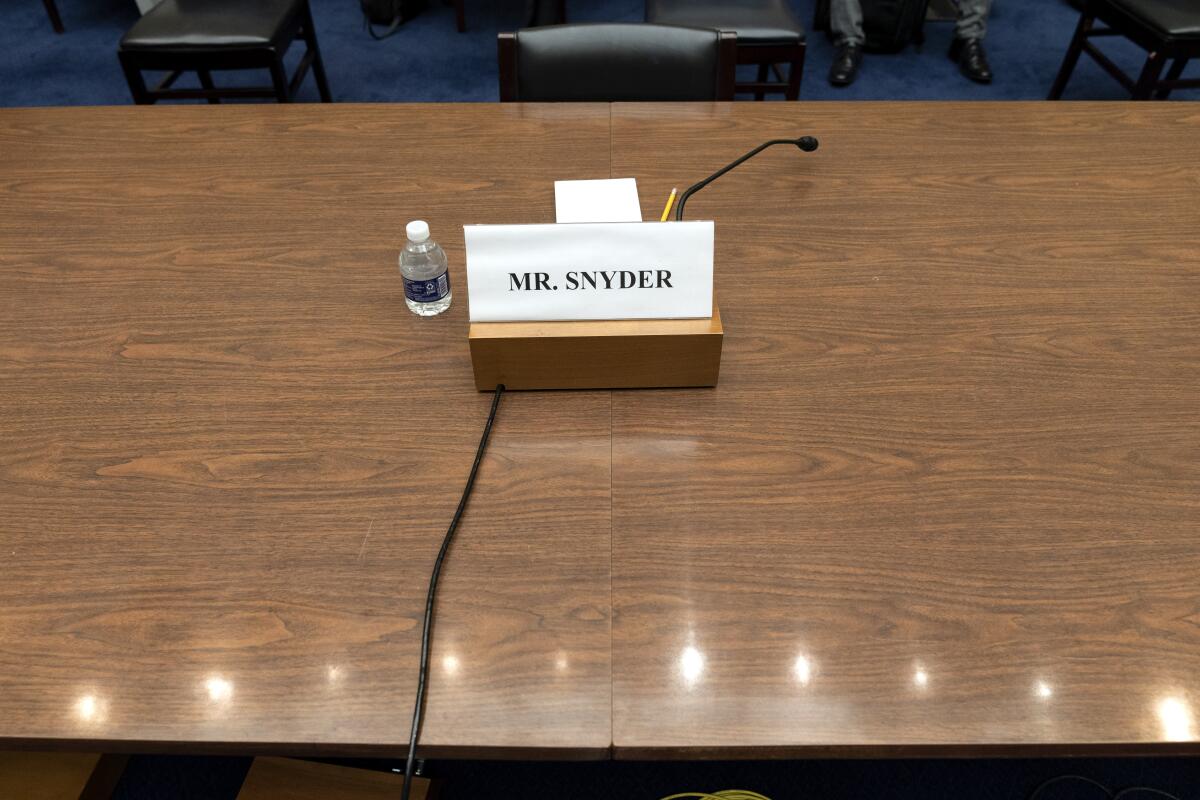 A placard for Dan Snyder, owner of the Washington Commanders football team, is seen, Wednesday, June 22, 2022, during a House Oversight Committee hearing on the Washington Commanders' workplace conduct, on Capitol Hill in Washington. Snyder did not attend the hearing virtually or otherwise. (AP Photo/Jacquelyn Martin)