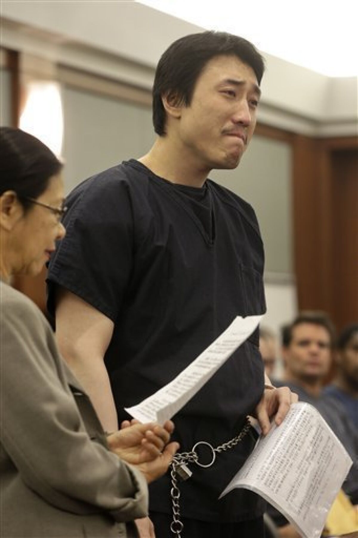Xiao Ye Bai reads a statement to the court during his sentencing, Tuesday, March 5, 2013, in Las Vegas. The 26-year-old Chinese immigrant, convicted of being an enforcer for a Taiwan-based criminal gang, will spend the rest of his life in a Nevada prison for killing one person and wounding two others in a bloody knife attack in a Las Vegas karaoke bar in July 2009. (AP Photo/Julie Jacobson)