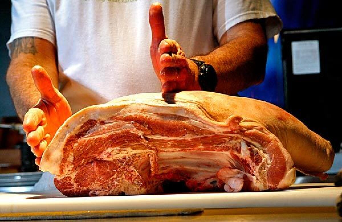 Paul Buchanan, chef of Primal Alchemy catering company, breaks down a pig.