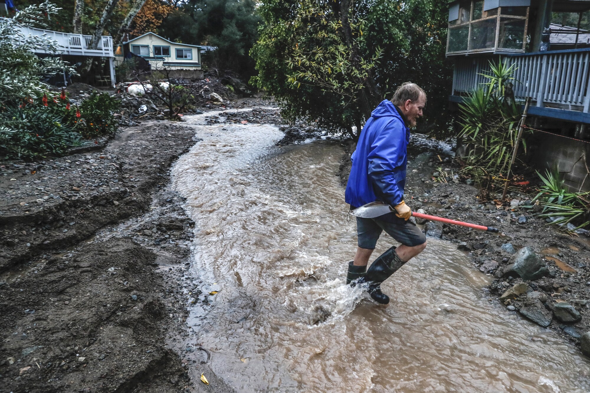 Mitch Vincent keeps an eye on a rising water current that threatens his parents' home. 
