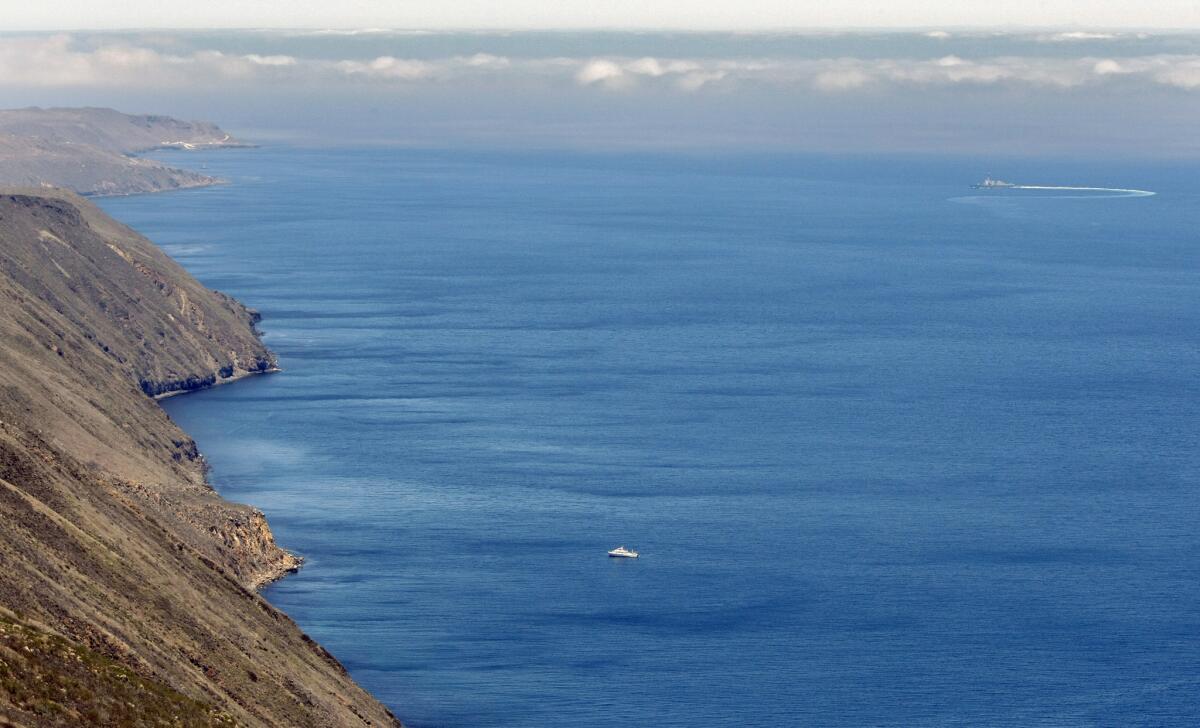 A U.S. Navy destroyer conducts a training exercise off the east coast of San Clemente Island. A body found this week about 100 feet underwater near the island has been identified as a Navy employee missing since October.