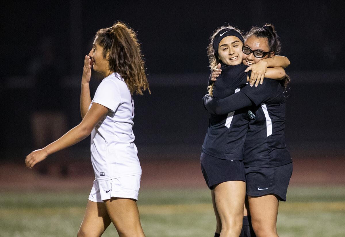 Costa Mesa's Natalia Guzman, center, hugs Lani Whittaker after Whittaker scored a goal in the 68th minute against Estancia during an Orange Coast League home match on Tuesday.