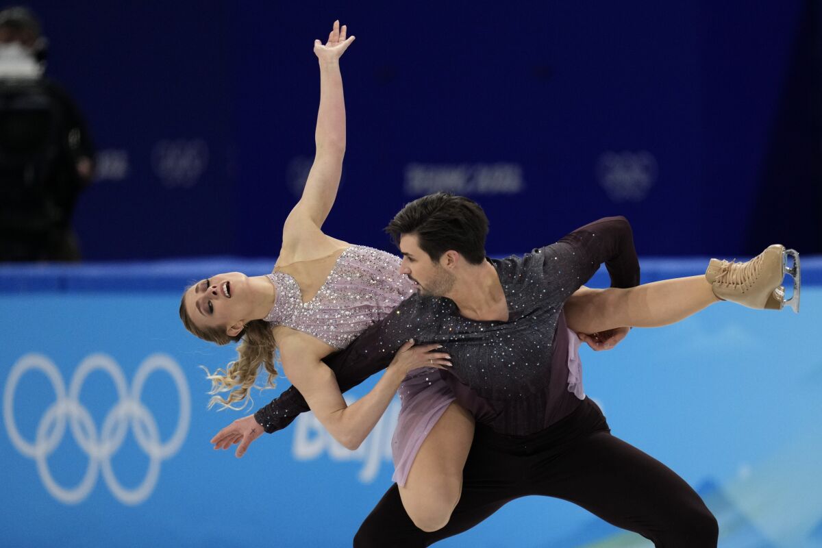 Zachary Donohue carries Madison Hubbell across his back as part of their ice dance routine.