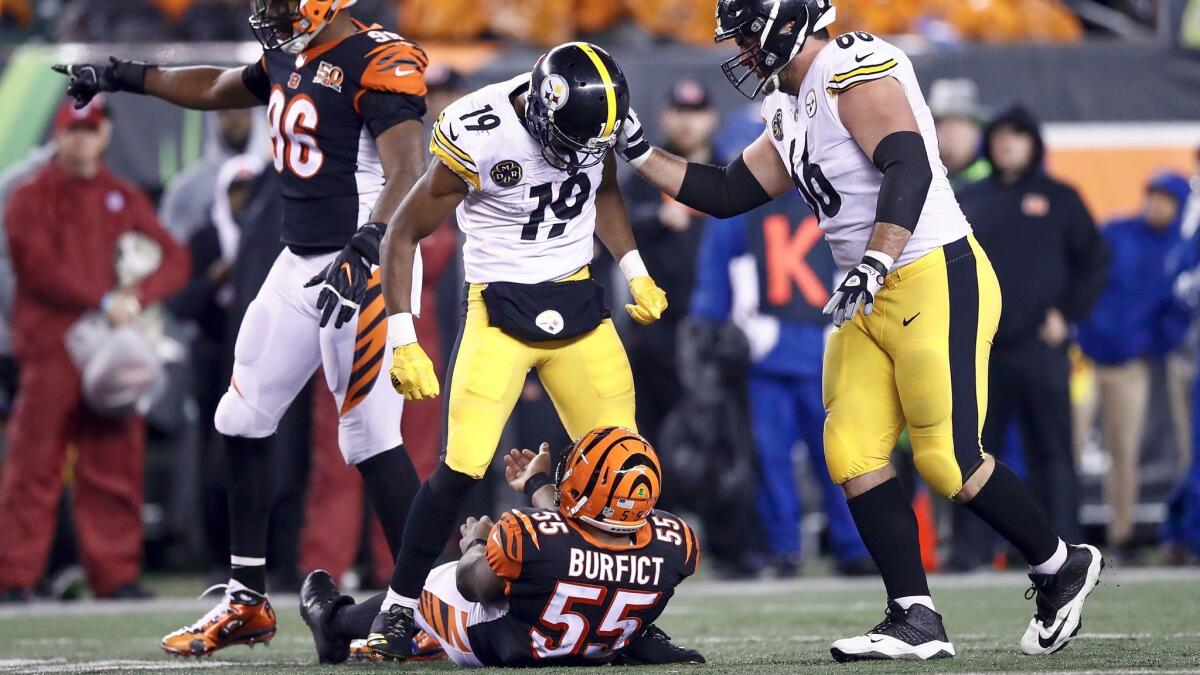 Pittsburgh's JuJu Smith-Schuster stands over Cincinnati 's Vontaze Burfict after injuring the Bengals player with a helmet hit during the teams' game on Dec. 4.