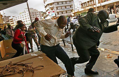 People flee downtown Nairobi as riot police chase protesters from the streets.