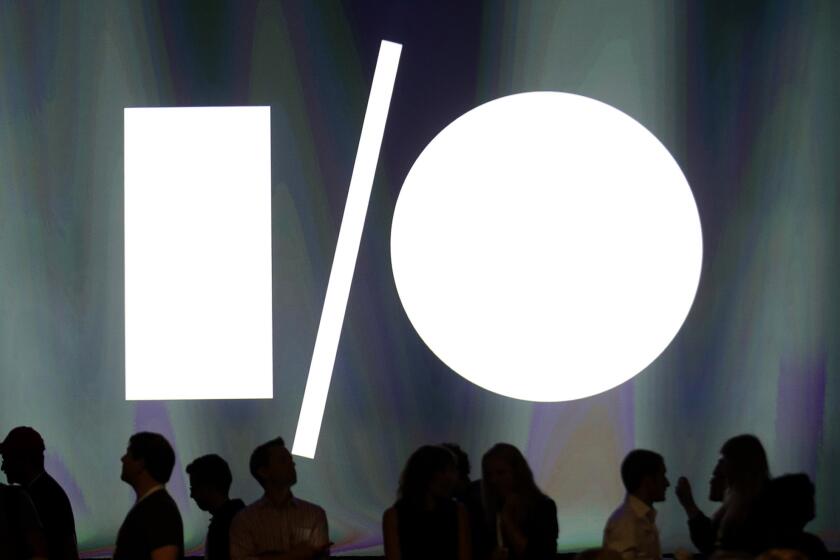 Attendees at the Google I/O 2014 keynote presentation stand in front of display screen at the Moscone Center in San Francisco.