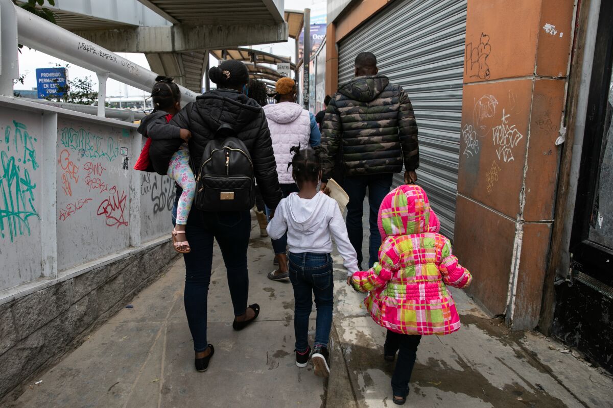 Landy, Anthony and their three young girls walk to the San Ysidro Port of Entry
