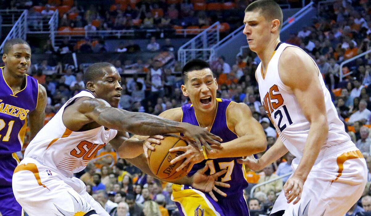 Lakers point guard Jeremy Lin tries to drive down the lane against Suns point guard Eric Bledsoe and center Alex Len on Wednesday night in Phoenix. Bledsoe was called for a foul on the play.