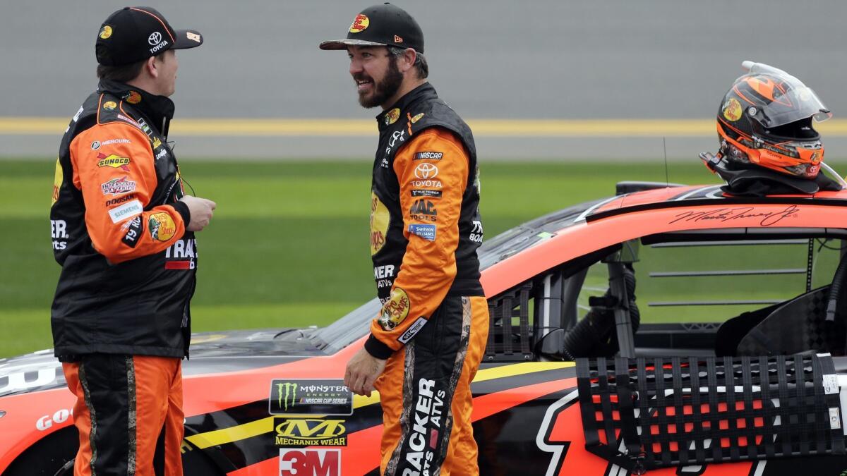 Martin Truex Jr., right, shown talking to a crew member this week at Daytona International Speedway, will be taking over the No. 19 Toyota for Joe Gibbs Racing this season.
