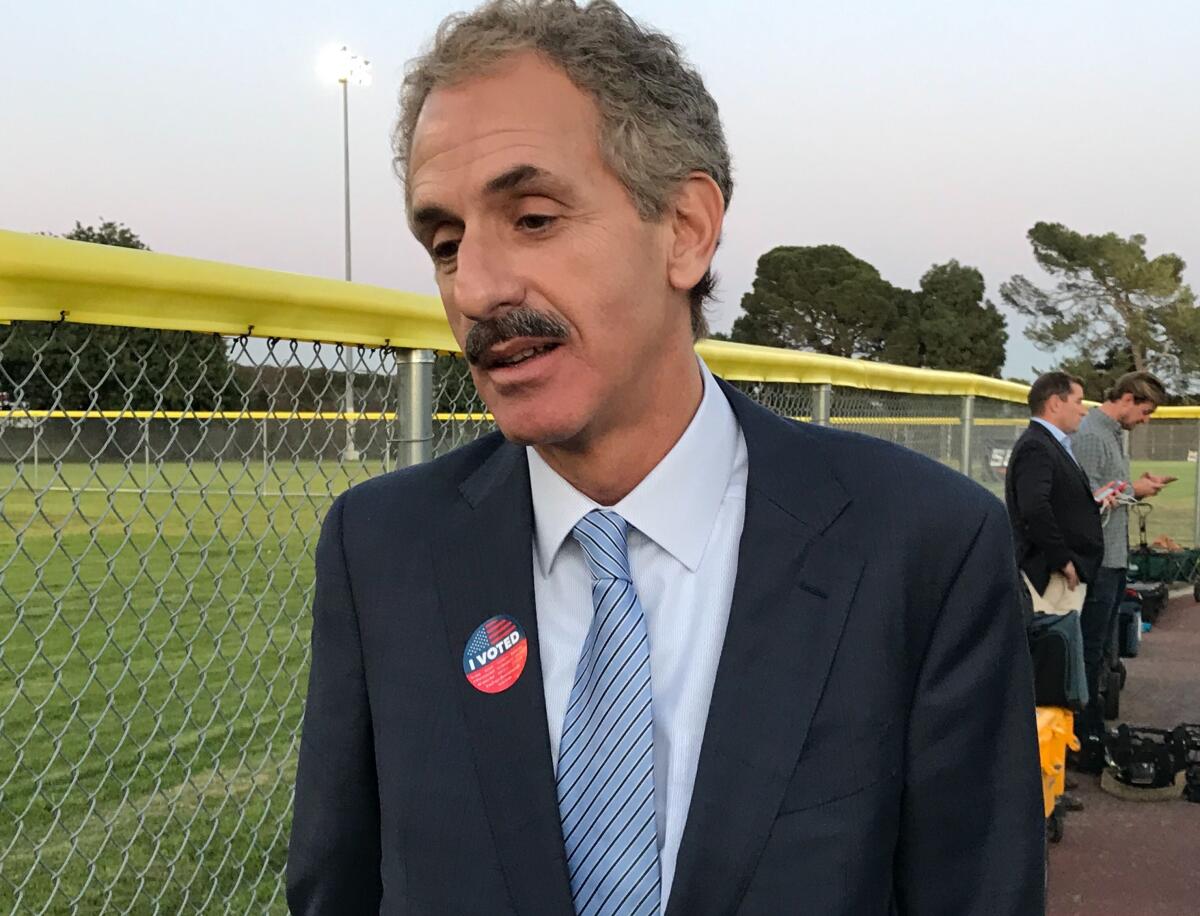 A man in a suit with an "I Voted" sticker on it.