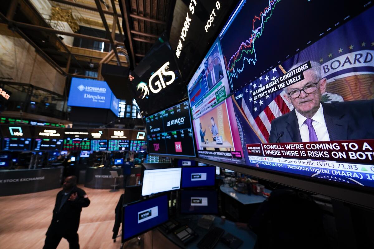 A man is shown on a large video monitor on the floor of the New York Stock Exchange.
