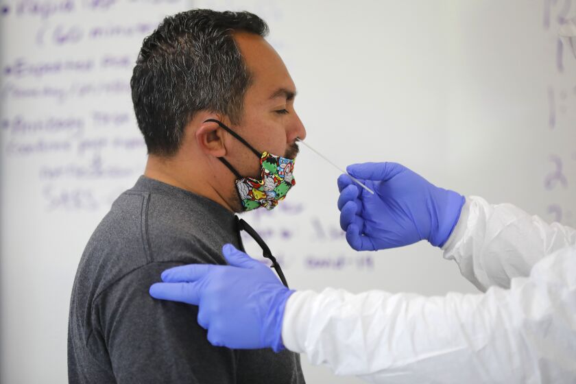 SAN MARCOS, CA - NOVEMBER 16: Memo Aguilar gets a Covid-19 test at Cal State University San Marcos, one of the busiest testing centers in San Diego County on Monday, Nov. 16, 2020 in San Marcos, CA. (K.C. Alfred / The San Diego Union-Tribune)