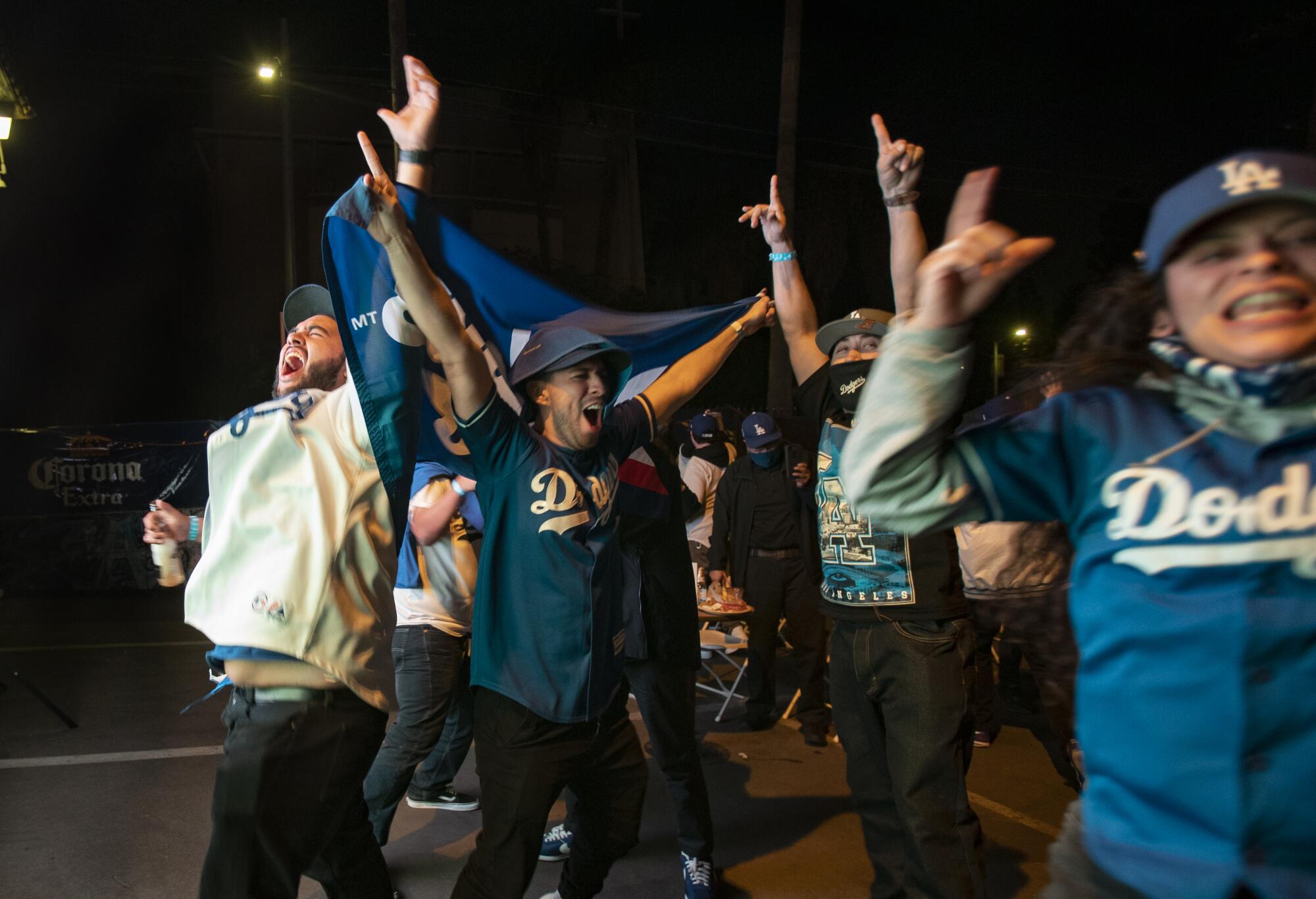 Jeff Gomez, Marlon Gomez and Juvenal Padilla lift their arms and yell. 