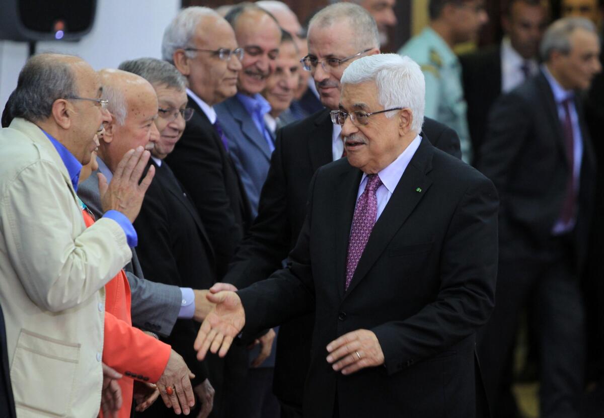Palestinian Authority President Mahmoud Abbas, right, and Palestinian Authority Prime Minister Rami Hamdallah, behind him, greet members of the new Palestinian unity government in the West Bank city of Ramallah.