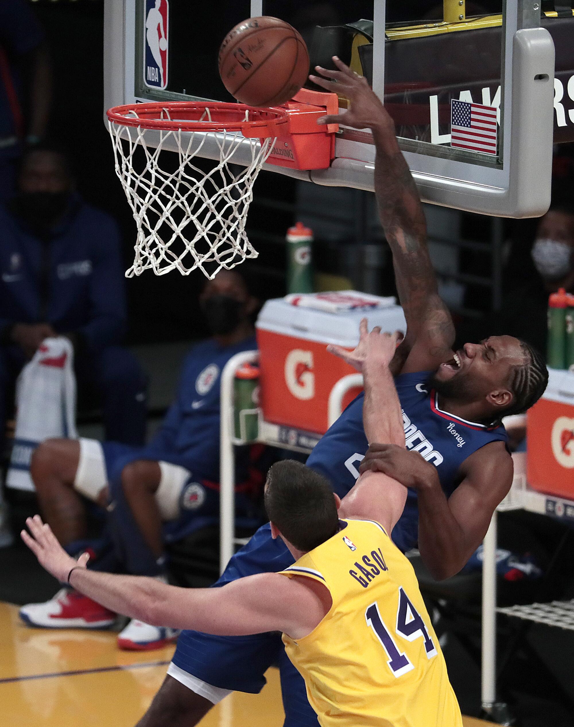 Clippers forward Kawhi Leonard (2) is fouled by Lakers center Marc Gasol on a layup during the first half.