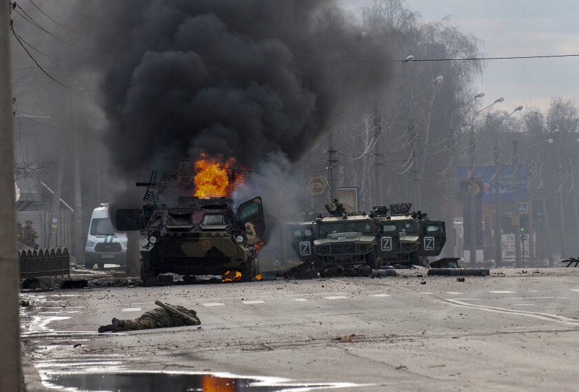 ARCHIVO - Un vehículo blindado ruso de transporte de tropas arde entre vehículos ligeros dañados