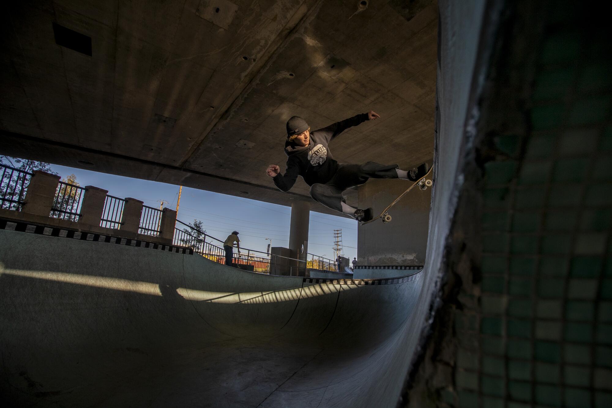 A skater does a trick in solitude at the Channel Street Skatepark.