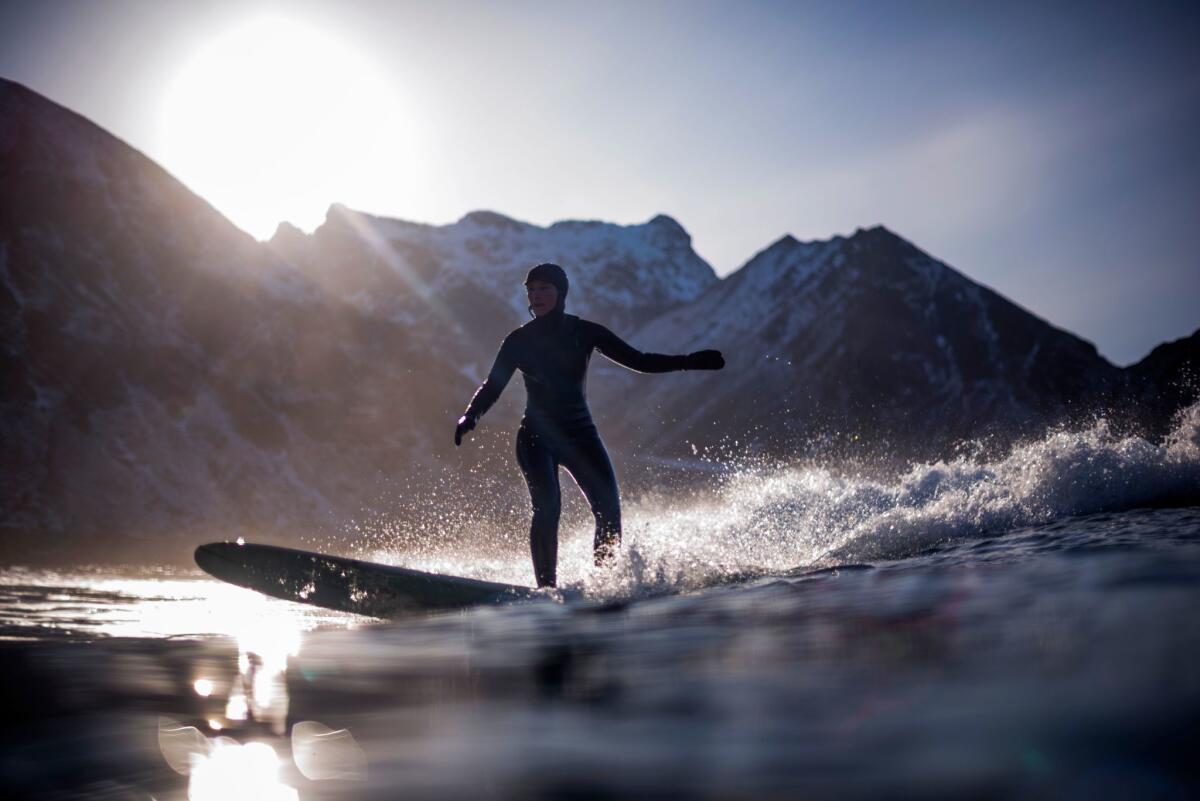 A surfer rides a wave in Unstad, within the Arctic Circle, as the air temperature drops to 37 below zero.