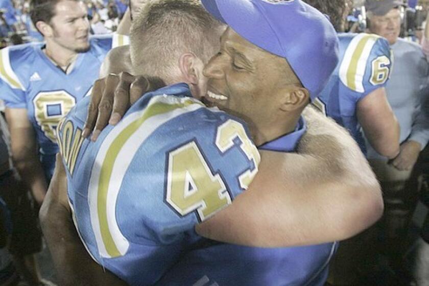 UCLA Coach Karl Dorrell celebrates after the victory with Danny Nelson.