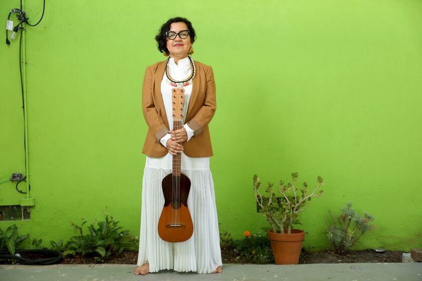 LOS ANGELES, CA - JULY 16: Martha Gonzalez, band member of music group Quetzal, has a new book coming out: Chican@ (cq) Artivistas: Music, Community, and Transborder Tactics in East Los Angeles," at her home on Thursday, July 16, 2020 in Los Angeles, CA. Martha is holding a Jarana, an eight string five course guitar, made by Gilberto Gutierrez, of Veracruz.(Gary Coronado / Los Angeles Times)