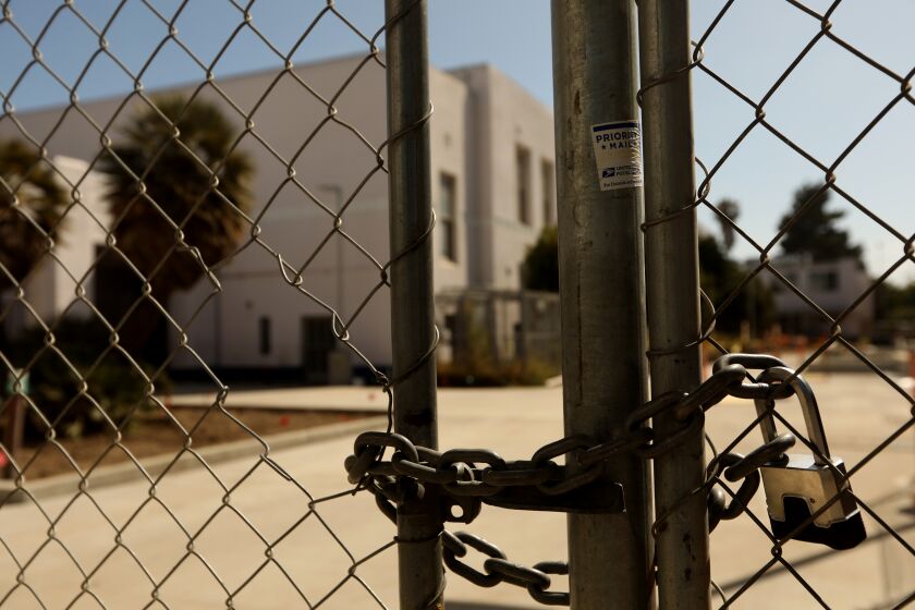 VENICE, CA - JULY 13, 2020 - - A padlock keeps the campus of Venice High School shuttered in Venice on July 13, 2020. Los Angeles campuses will not reopen for classes on Aug. 18, and the nation's second-largest school system will continue with online learning until further notice, because of the worsening coronavirus surge, Supt. Austin Beutner announced Monday. "Let me be crystal clear," Beutner said in an interview with The Times. "We all know the best place for students to learn is in a school setting." But, he said, "We're going in the wrong direction. And as much as we want to be back at schools and have students back at schools - can't do it until it's safe and appropriate." (Genaro Molina / Los Angeles Times)