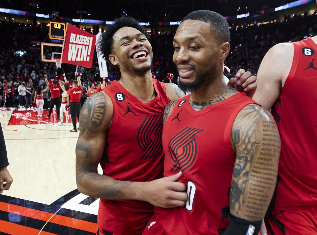 Portland Trail Blazers guard Anfernee Simons, left, and guard Damian Lillard smile after the team's win in an NBA basketball game against the Phoenix Suns in Portland, Ore., Friday, Oct. 21, 2022. (AP Photo/Craig Mitchelldyer)