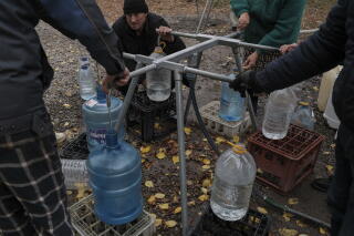 People fill water in bottles.