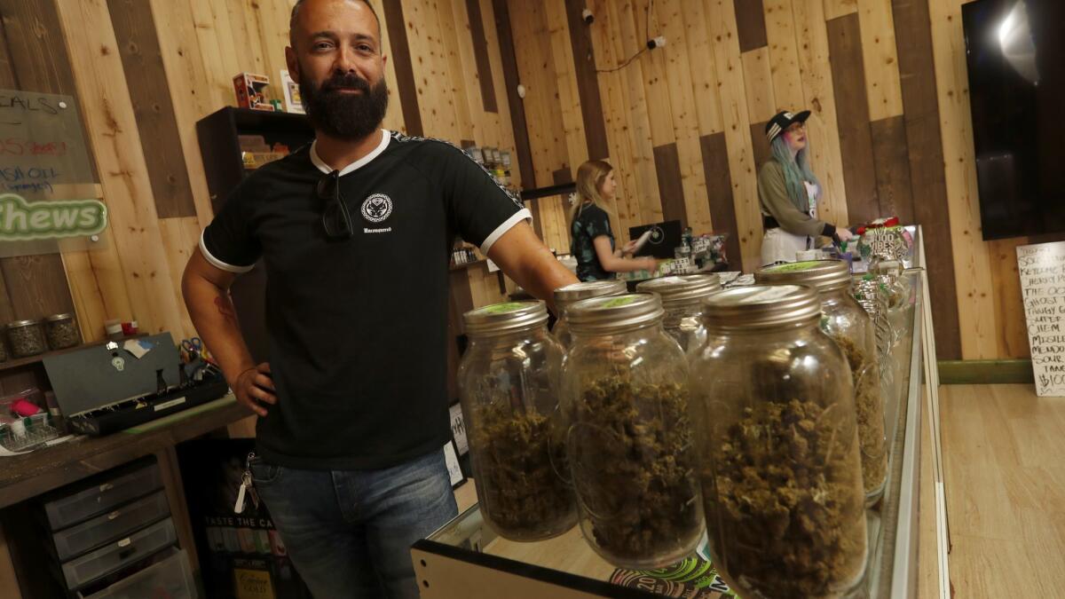 Joseph Tintari, owner of Greenlight Discount Pharmacy, a marijuana shop in Sylmar, is photographed inside the showroom Friday. Temporary four-month permits are expiring and cannabis retailers must now get costly annual permits, which many say is a financial burden.