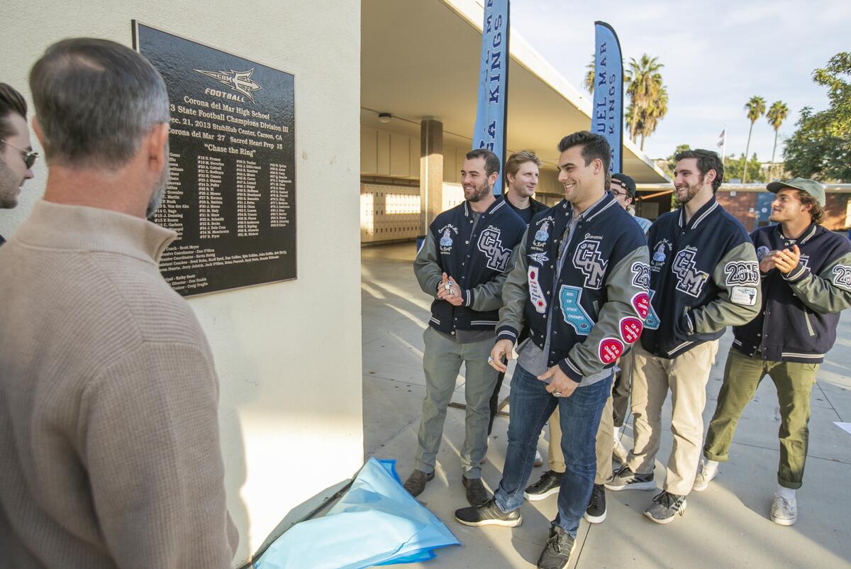 Giovanni Gentosi, in front on the right, and his 2013 Corona del Mar teammates admire a plaque honoring the football program's first CIF State title.