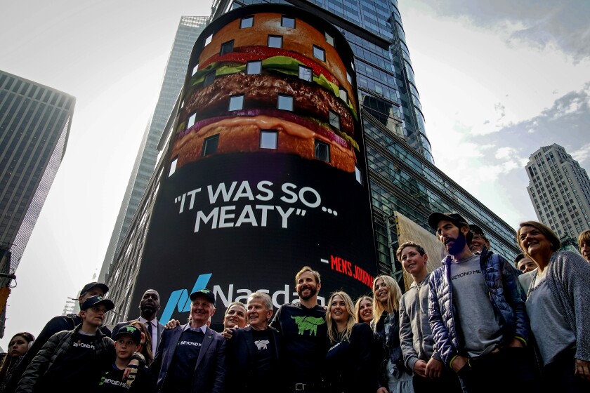 Ethan Brown with guests in front of a Beyond Meat ad in Times Square