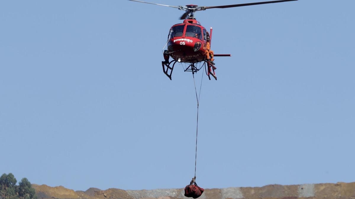 A helicopter lifts a body recovered from the mud after the dam collapse in Brumadinho, Brazil.