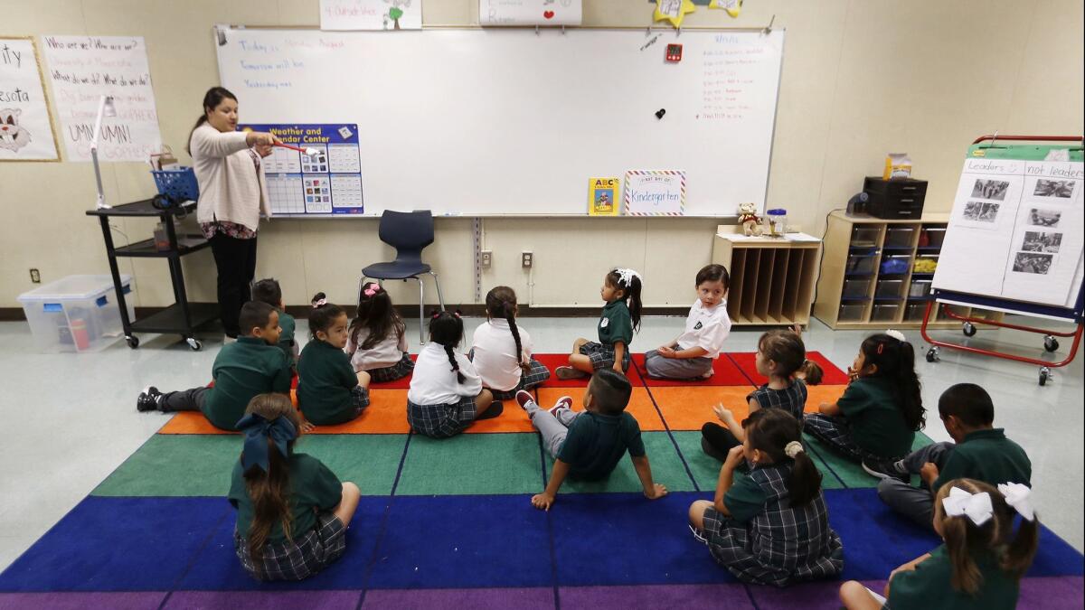 A kindergarten teacher works with students in Los Angeles on August 13.