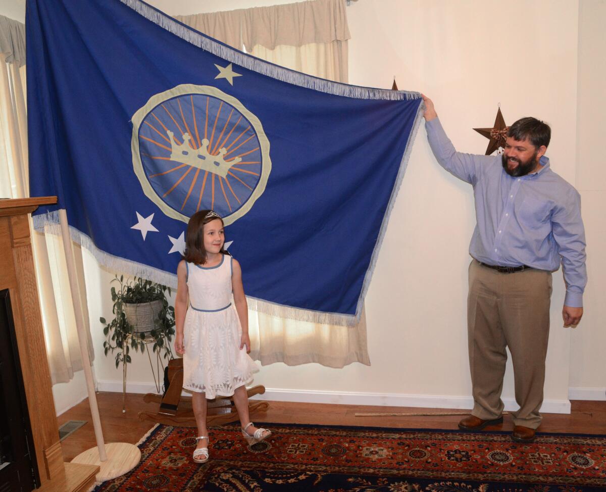 Jeremiah Heaton and his 7-year-old daughter, "Princess" Emily, show the flag that their family designed as they try to claim a piece of land in the Eastern African region of Bir Tawil.