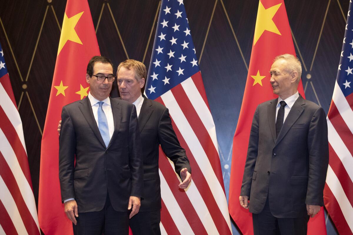 El representante comercial estadounidense Robert Lighthizer, al centro, intercambia posición con el secretario del Tesoro Steven Mnuchin, mientras a la derecha se encuentra el vicepresidente chino Liu He looks, en el Centro de Conferencias Xijiao, en Shanghai, el 31 de julio de 2019.