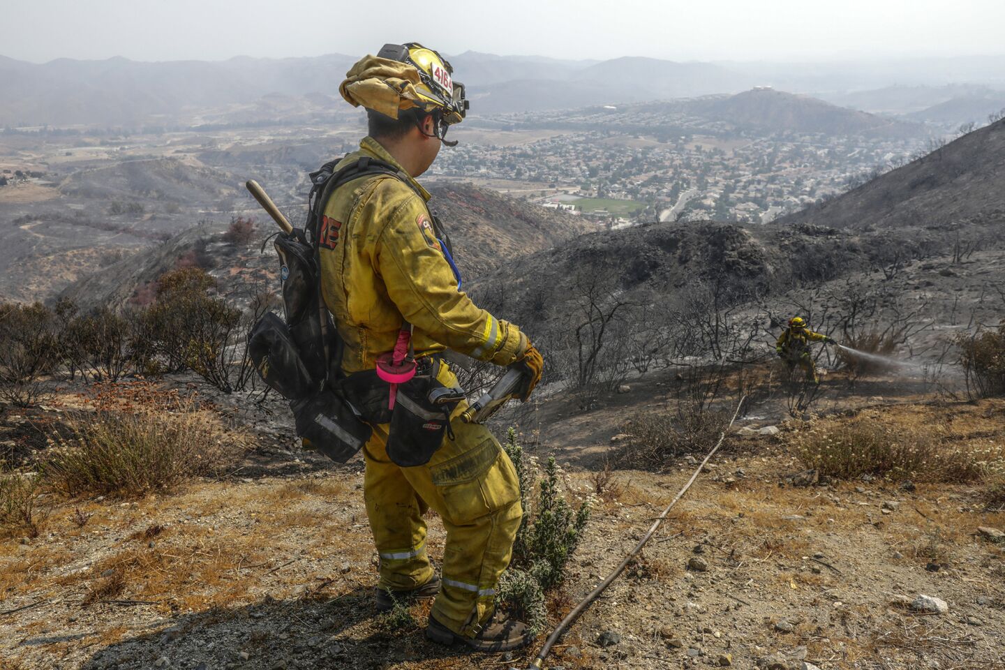 A firefighter douses hot spots in the McVicker Canyon neighborhood of Lake Elsinore.