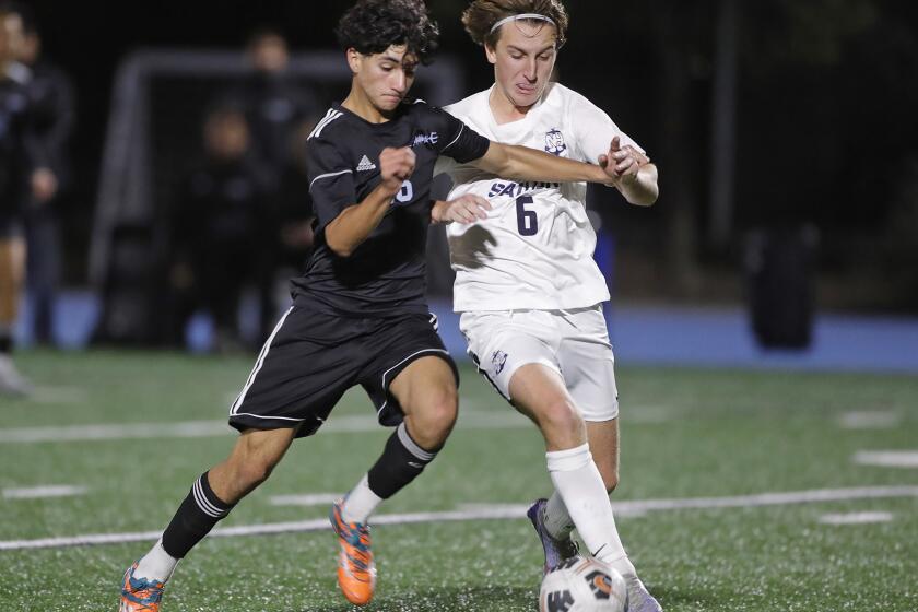Gavin Karam (16) of Corona del Mar and NewportOs James Evans battle for a loose ball at midfield during Battle of the Bay boysO soccer game on Monday.