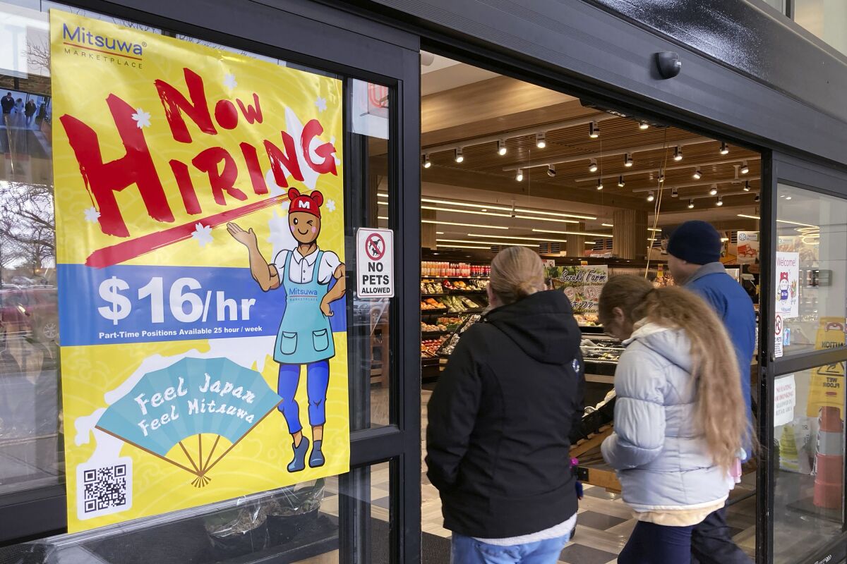 A hiring sign is displayed at a grocery store
