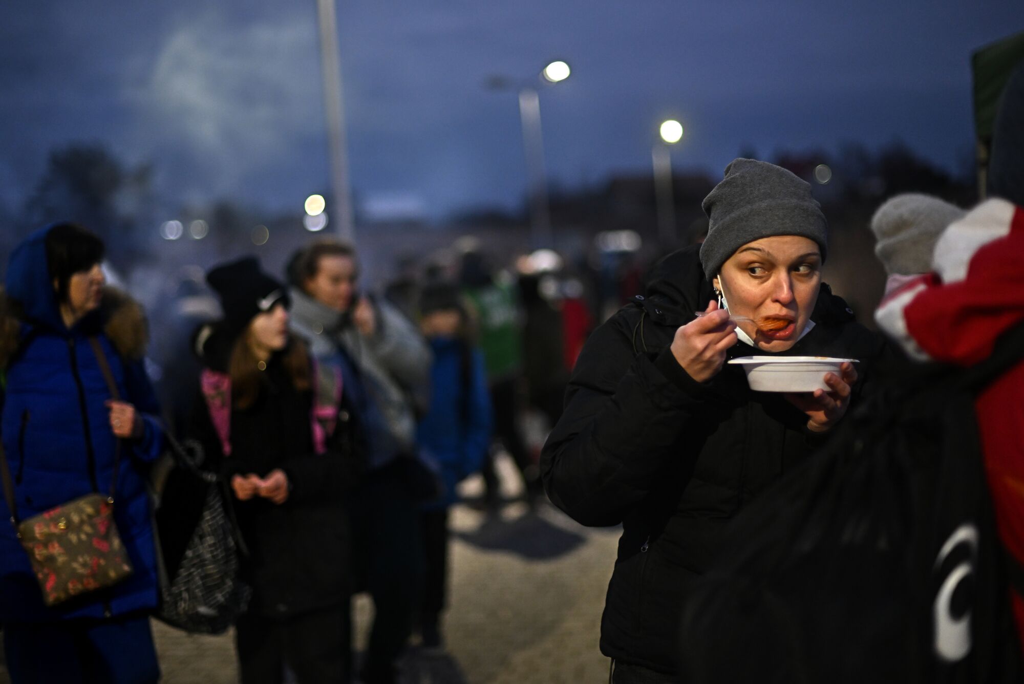 A refugee has a meal after crossing the border from Ukraine into Medyka, Poland, on Saturday. 