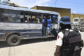 Un camión pasa frente a un agente de policía cerca del aeropuerto de Puerto Príncipe, Haití, el viernes 24 de mayo de 2024. (AP Foto/Odelyn Joseph)