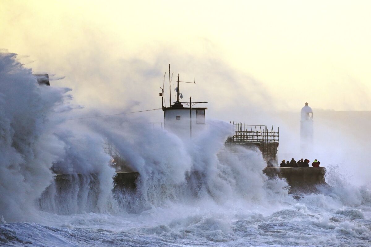 Waves crash against a sea wall.