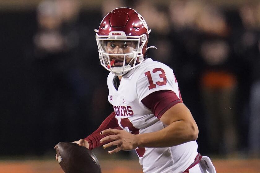 Oklahoma quarterback Caleb Williams (13) scrambles during an NCAA college football game against Oklahoma State, Saturday, Nov. 27, 2021, in Stillwater, Okla. (AP Photo/Sue Ogrocki)